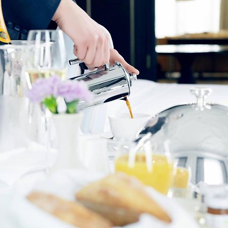 The St. Regis Astana Hotel Eksteriør billede A server pouring orange juice